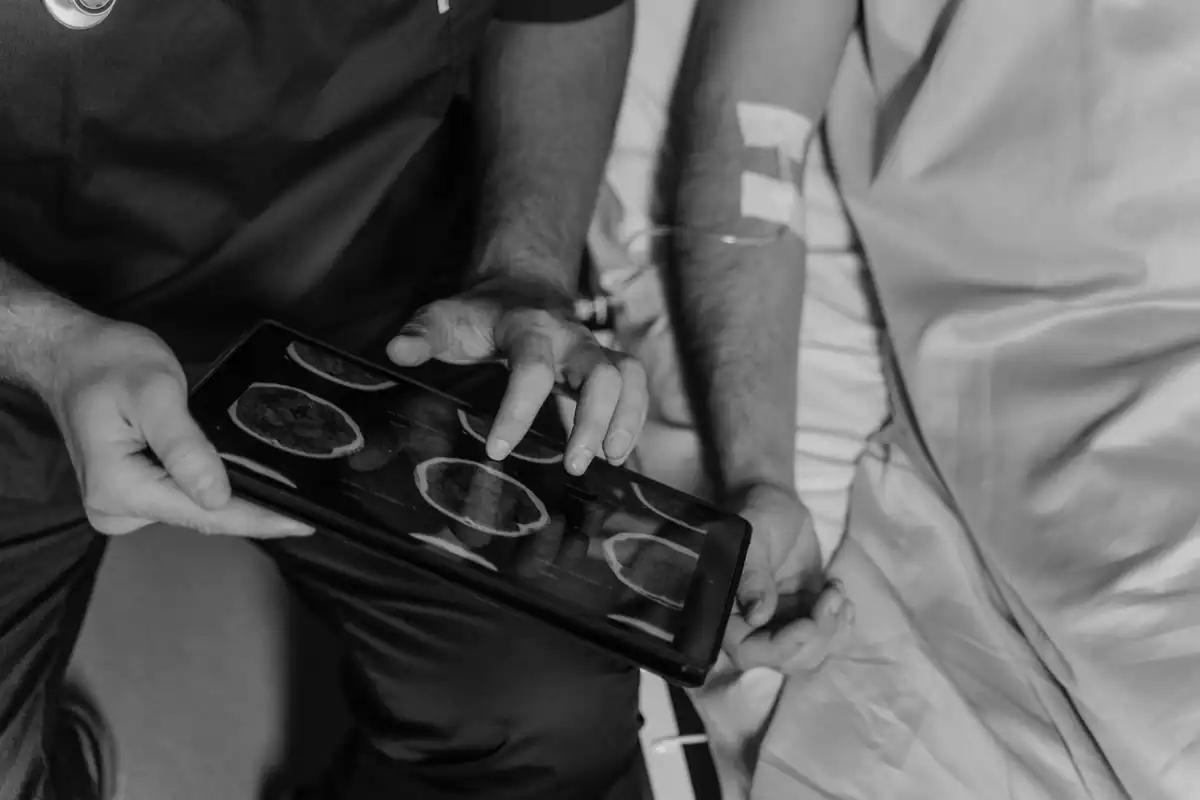 Medic care privește imagini CT alb-negru pe o tabletă, pentru a doua opinie