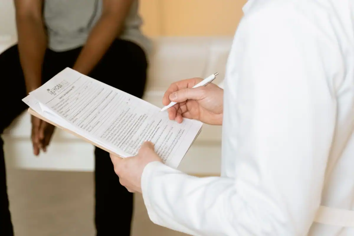 Medic verifică un formular medical în timpul consultației cu pacientul, într-o clinică