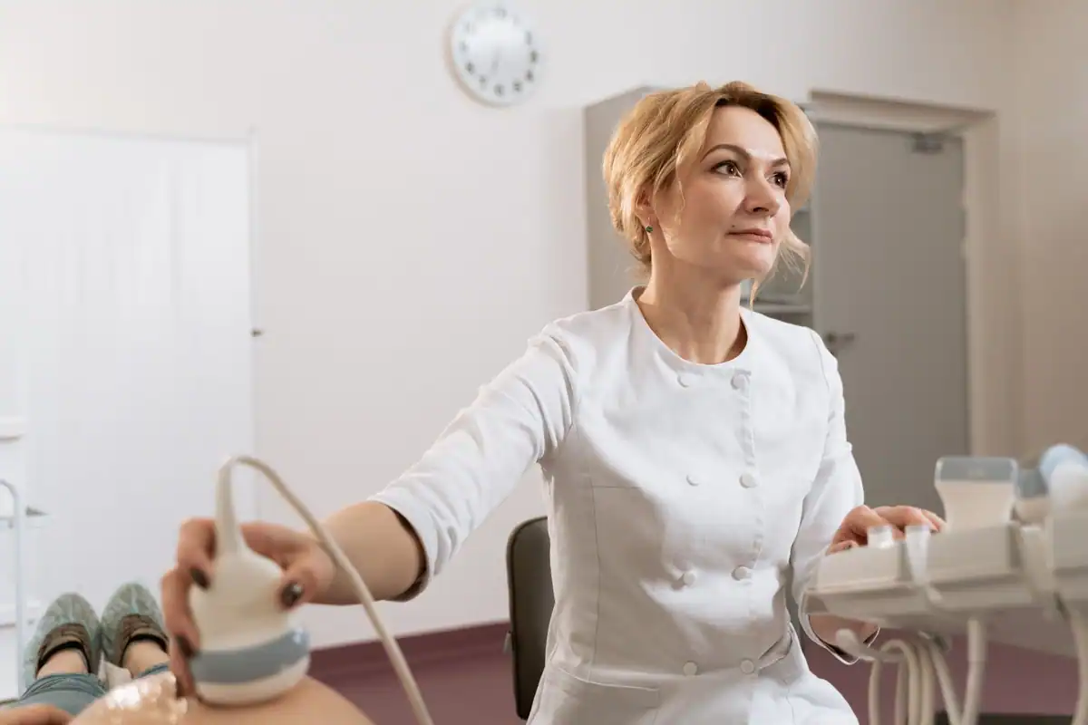 Medic care efectuează o ecografie unei paciente, într-un cabinet medical modern